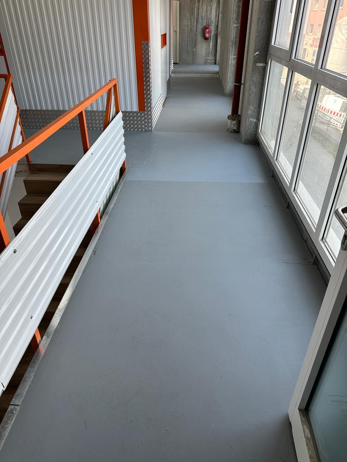 Heller Laufgang im Obergeschoss mit großen Fenstern und Blick über Bochum